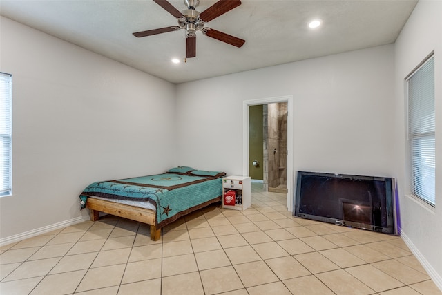 bedroom featuring light tile patterned floors, ceiling fan, and ensuite bathroom