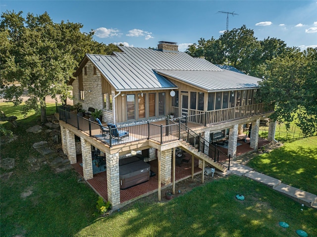 back of house with a yard, a sunroom, and a deck