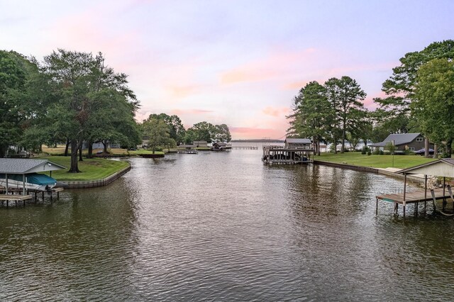 aerial view at dusk featuring a water view