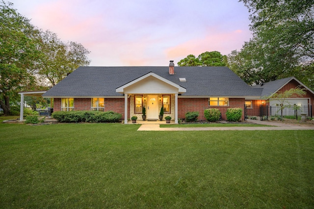 view of front of house featuring brick siding, a lawn, a chimney, and fence