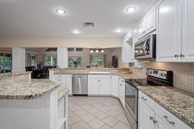 kitchen with kitchen peninsula, white cabinets, and appliances with stainless steel finishes