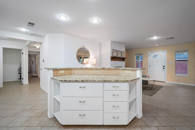 kitchen with visible vents, open shelves, tasteful backsplash, and light stone counters