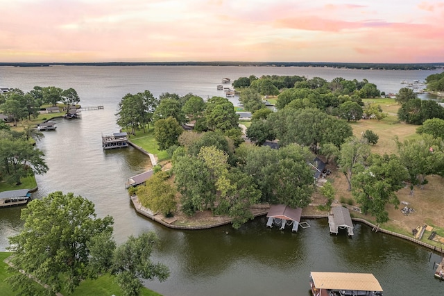 aerial view at dusk featuring a water view