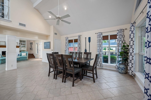 dining area featuring ceiling fan, high vaulted ceiling, light tile patterned flooring, and visible vents