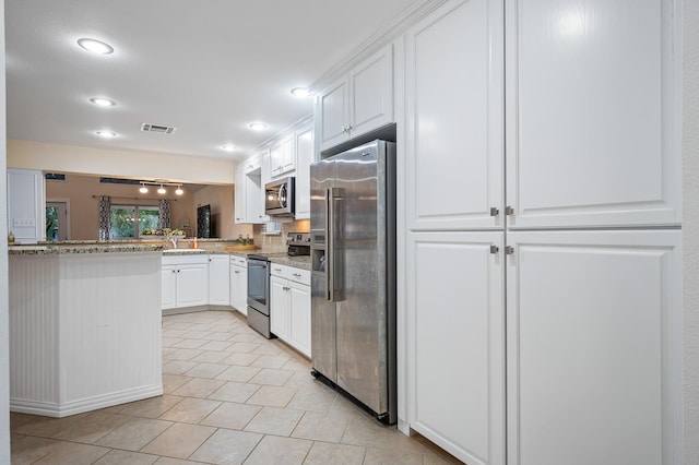 kitchen with stainless steel appliances, white cabinets, visible vents, and light stone countertops