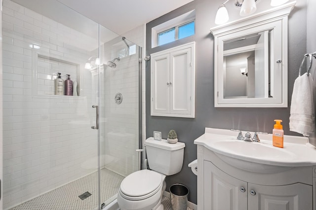 full bath with vanity, a shower stall, and toilet