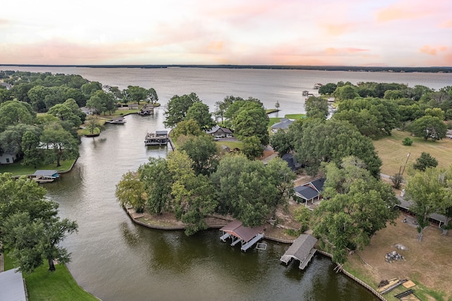 aerial view at dusk featuring a water view