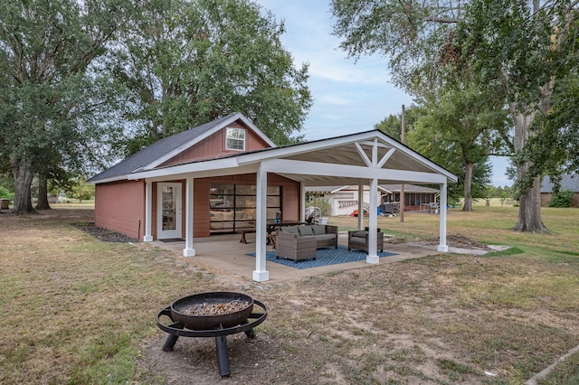 view of patio with an outdoor living space with a fire pit