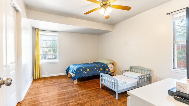 bedroom featuring hardwood / wood-style flooring, ceiling fan, and a closet