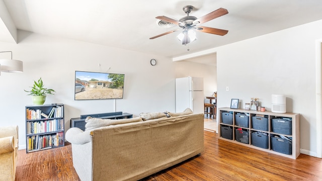 living room featuring wood-type flooring and ceiling fan