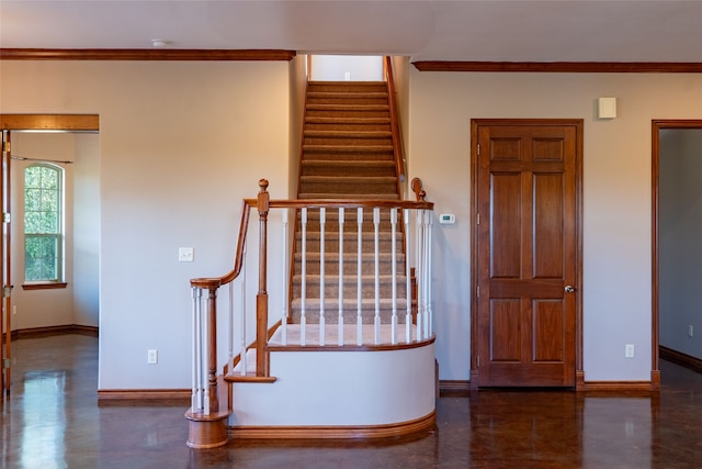 staircase with concrete floors and crown molding