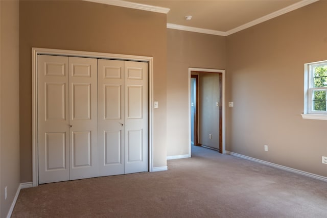 unfurnished bedroom with crown molding, light colored carpet, and a closet