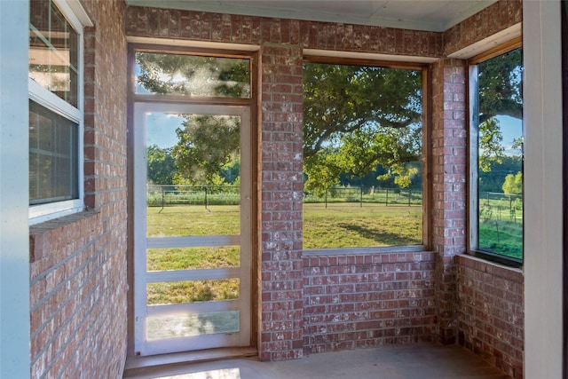 doorway to outside featuring a wealth of natural light and concrete flooring