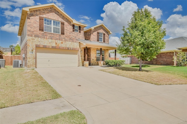 view of front of house with a front yard, central AC unit, and a garage