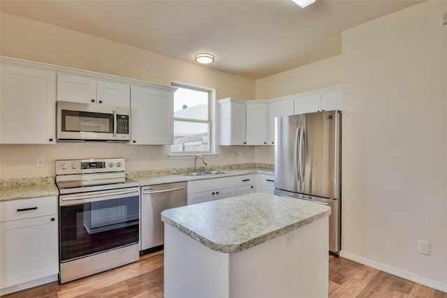 kitchen featuring white cabinetry, sink, light hardwood / wood-style floors, a kitchen island, and appliances with stainless steel finishes