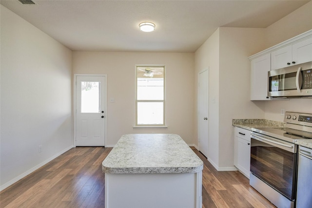 kitchen with white cabinetry, a kitchen island, dark wood-type flooring, and appliances with stainless steel finishes