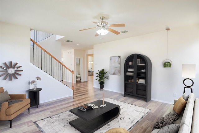 living room featuring ceiling fan and light hardwood / wood-style flooring