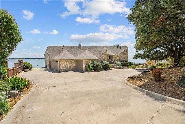 view of front of property with a garage and a water view