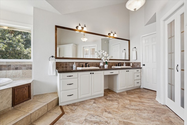 bathroom featuring vanity, a bath, decorative backsplash, and tile patterned floors