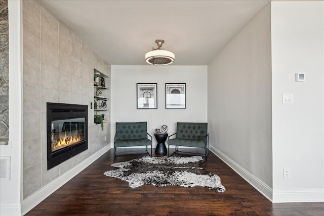 sitting room with tile walls, dark hardwood / wood-style floors, and a tile fireplace