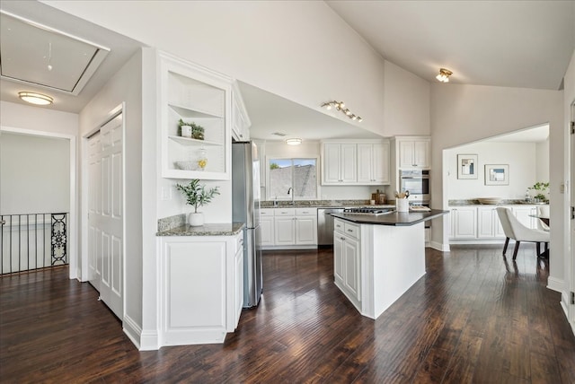 kitchen with white cabinets, built in shelves, appliances with stainless steel finishes, dark wood-type flooring, and a kitchen island