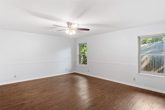 unfurnished room featuring a ceiling fan, dark wood-type flooring, and baseboards