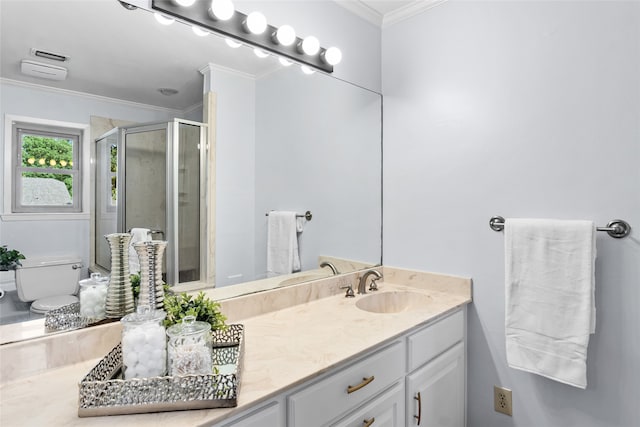 bathroom with crown molding, vanity, toilet, and a shower with door