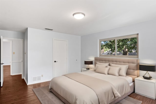 bedroom with visible vents, baseboards, and wood finished floors