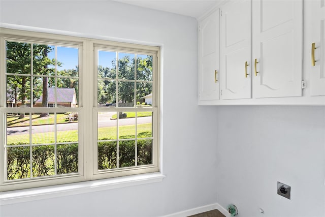 washroom featuring electric dryer hookup, baseboards, cabinet space, and gas dryer hookup