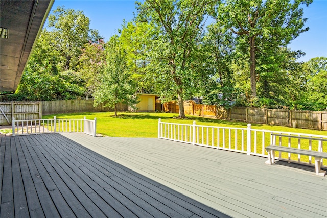 wooden terrace featuring a lawn and a shed