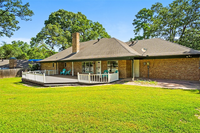 rear view of property featuring a wooden deck and a lawn