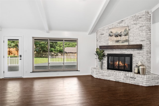 unfurnished living room featuring lofted ceiling with beams, a brick fireplace, and dark hardwood / wood-style floors