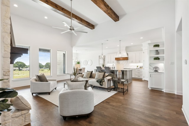 living room with ceiling fan, dark hardwood / wood-style floors, and beam ceiling