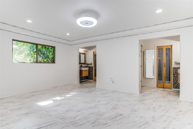 spare room featuring light marble finish flooring, ceiling fan, and baseboards