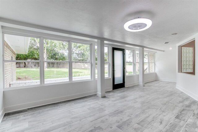 unfurnished living room featuring baseboards and wood finished floors