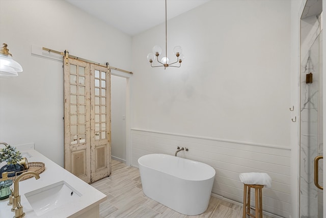 bathroom featuring vanity, an inviting chandelier, and shower with separate bathtub