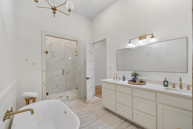 bathroom with vanity, a notable chandelier, separate shower and tub, and hardwood / wood-style floors