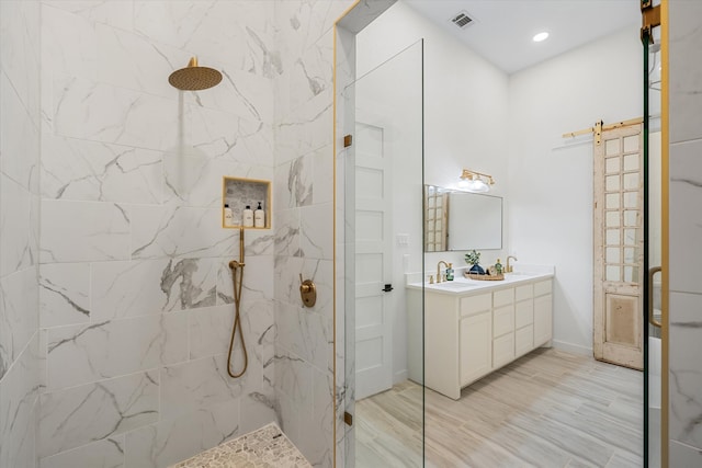 bathroom featuring vanity, tiled shower, and hardwood / wood-style floors