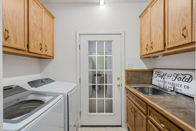 laundry area with sink, washer and dryer, light tile patterned floors, and cabinets