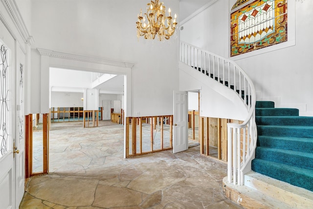 foyer entrance with crown molding and a chandelier