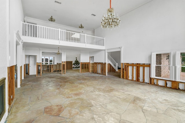 interior space with a high ceiling, light tile patterned floors, and a notable chandelier