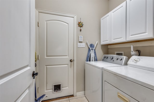 laundry area with cabinets, washer and dryer, and light tile patterned floors