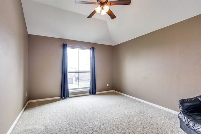 spare room featuring ceiling fan, carpet flooring, and vaulted ceiling