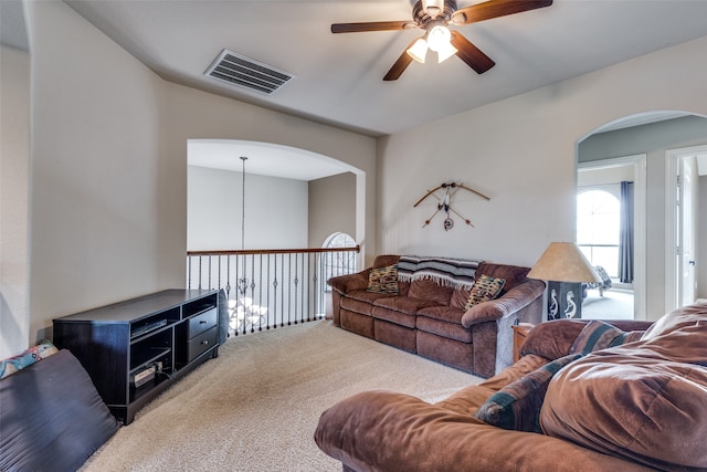 carpeted living room with ceiling fan