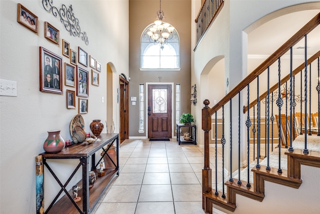 tiled foyer entrance with a high ceiling and a chandelier