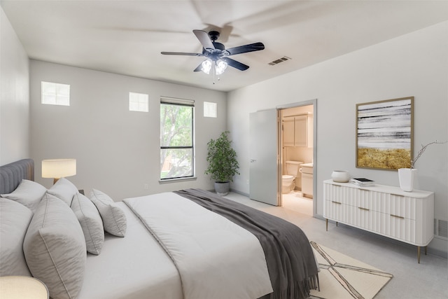 carpeted bedroom featuring ensuite bath and ceiling fan