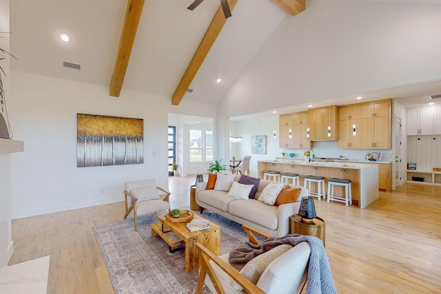 living room featuring light hardwood / wood-style flooring, beam ceiling, ceiling fan, and high vaulted ceiling