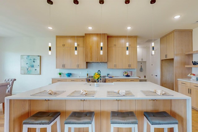 kitchen featuring light wood-type flooring, a center island, and light brown cabinets