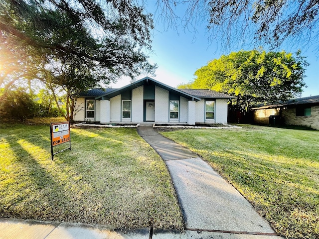 single story home featuring a front lawn