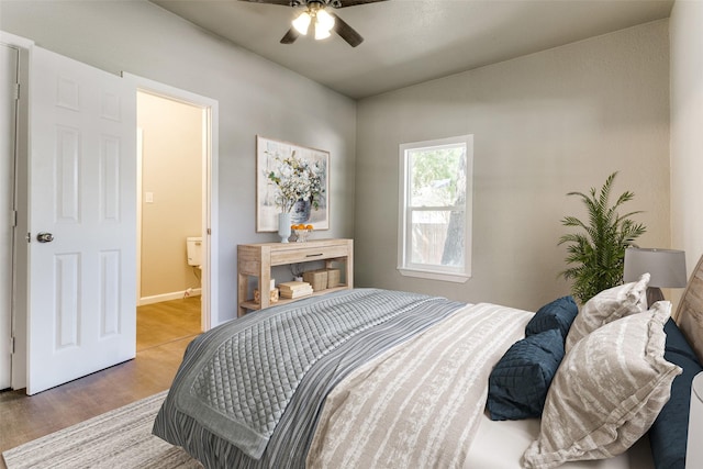 bedroom featuring ceiling fan, hardwood / wood-style floors, and connected bathroom